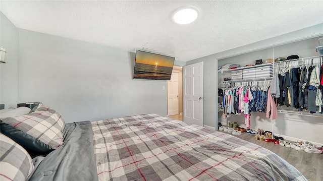 bedroom with light wood-type flooring, a closet, and a textured ceiling