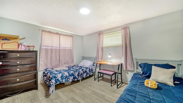 bedroom featuring light wood-type flooring and a textured ceiling