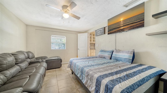 tiled bedroom featuring a textured ceiling and ceiling fan