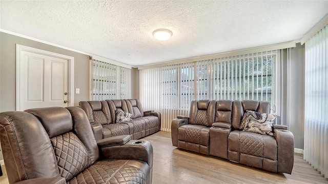 living room featuring crown molding, a textured ceiling, plenty of natural light, and light hardwood / wood-style floors