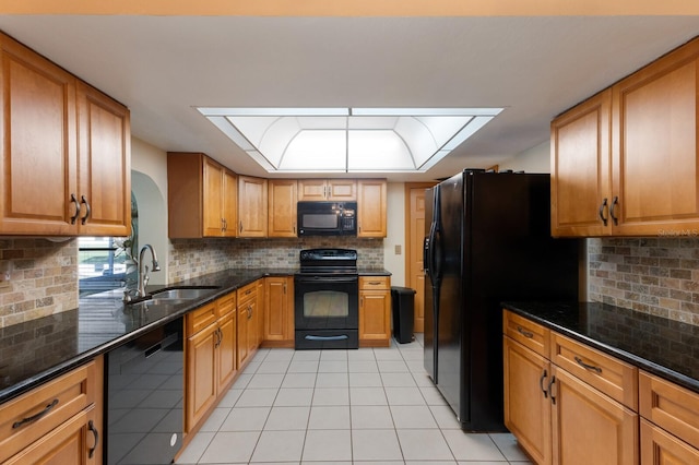 kitchen featuring backsplash, black appliances, sink, dark stone countertops, and light tile patterned flooring