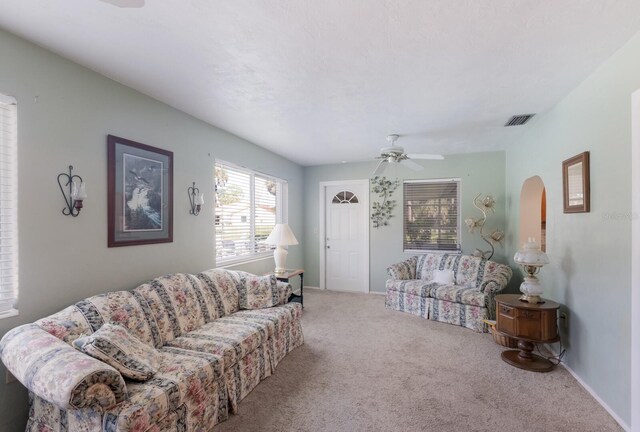 carpeted living room with ceiling fan