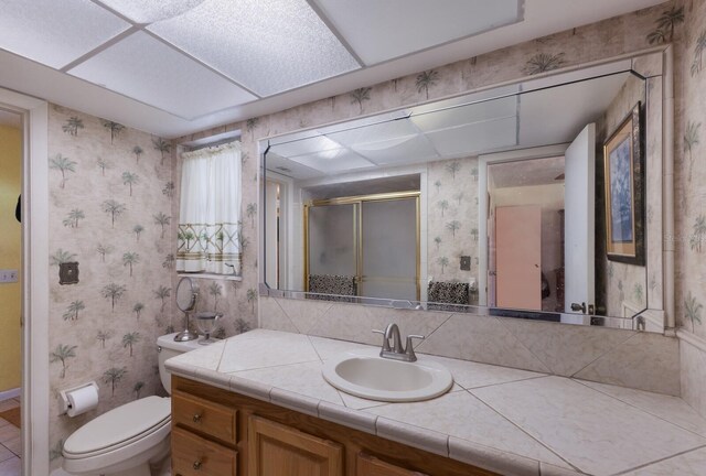 bathroom with toilet, vanity, and walk in shower