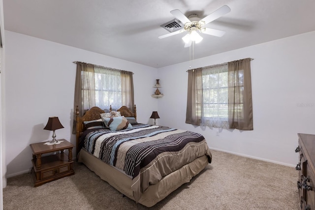 carpeted bedroom featuring ceiling fan and multiple windows