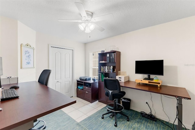 tiled office with a textured ceiling and ceiling fan