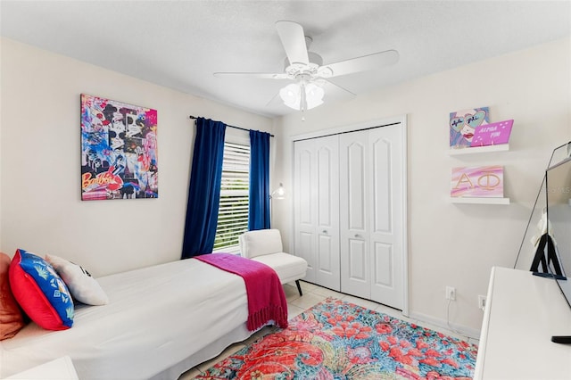 tiled bedroom featuring a closet, ceiling fan, and a textured ceiling