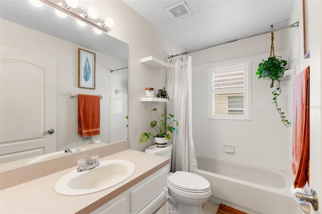 full bathroom with vanity, toilet, a textured ceiling, and shower / bath combo