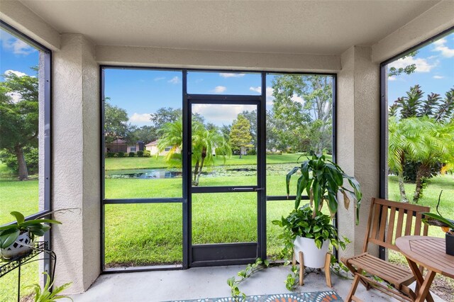 sunroom / solarium with a healthy amount of sunlight and a water view