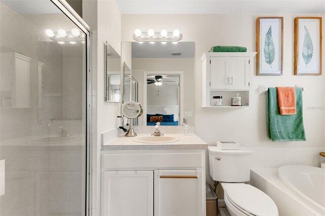 full bathroom featuring vanity, toilet, ceiling fan, and shower with separate bathtub