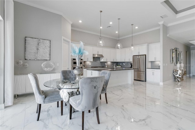 dining space featuring ornamental molding, sink, and a high ceiling