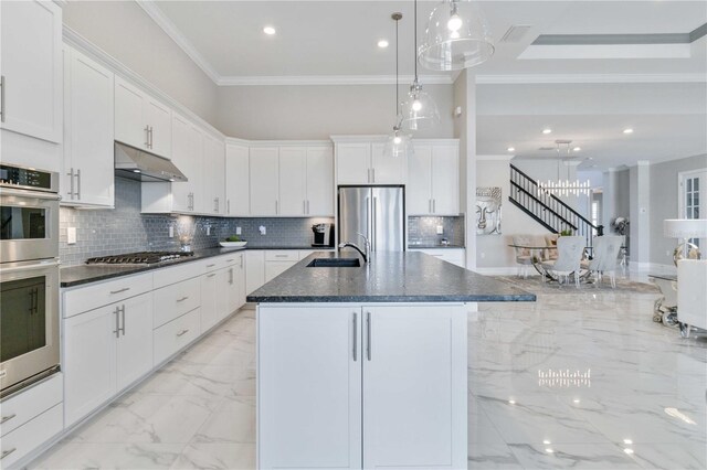 kitchen featuring white cabinetry, decorative light fixtures, and appliances with stainless steel finishes