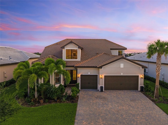 view of front of home with a garage and a lawn