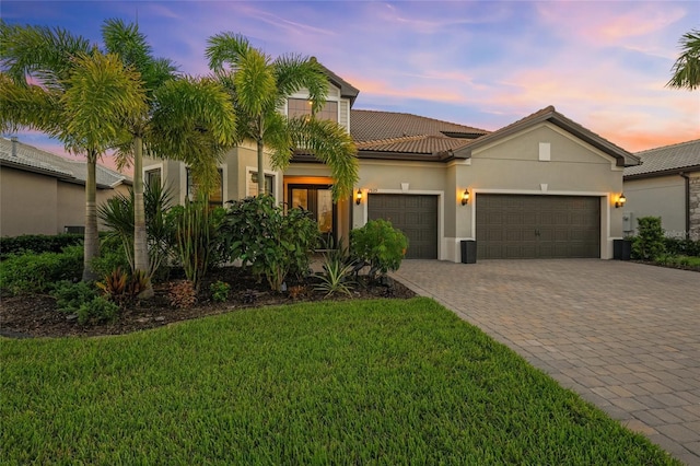 view of front of property with a garage and a lawn