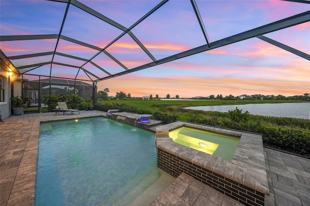 pool at dusk featuring a water view, pool water feature, a lanai, an in ground hot tub, and a patio area