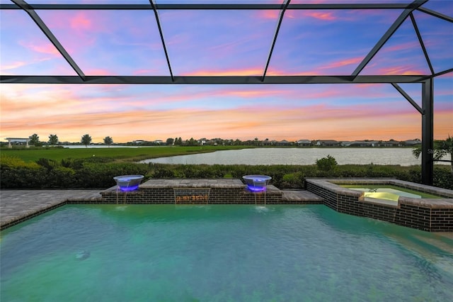 pool at dusk featuring an in ground hot tub, a water view, and a lanai