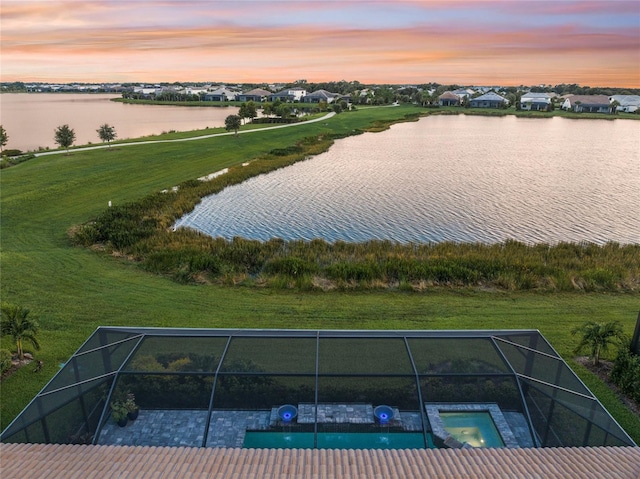 aerial view at dusk featuring a water view