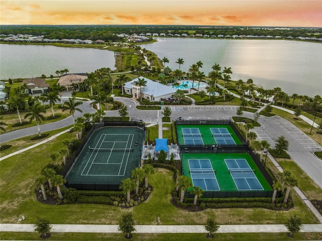 aerial view at dusk featuring a water view