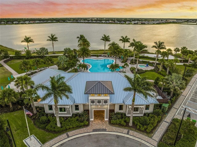 aerial view at dusk featuring a water view