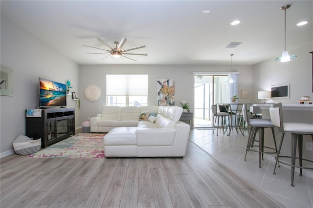 living room with light wood-type flooring and ceiling fan