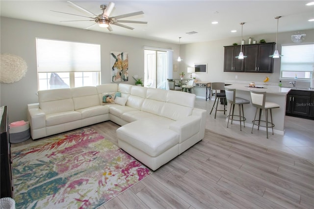 living room featuring light wood-type flooring and ceiling fan