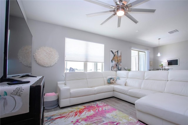 living room featuring light hardwood / wood-style flooring and ceiling fan