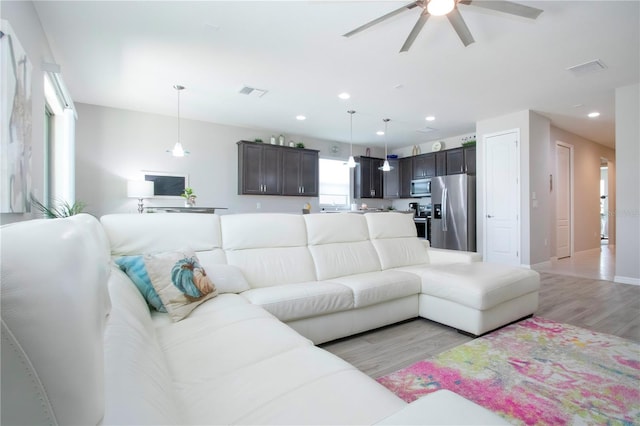 living room featuring ceiling fan and light hardwood / wood-style floors