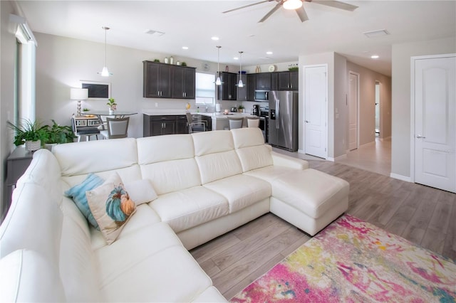 living room featuring ceiling fan and light wood-type flooring