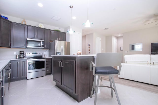 kitchen featuring a center island, appliances with stainless steel finishes, and dark brown cabinets