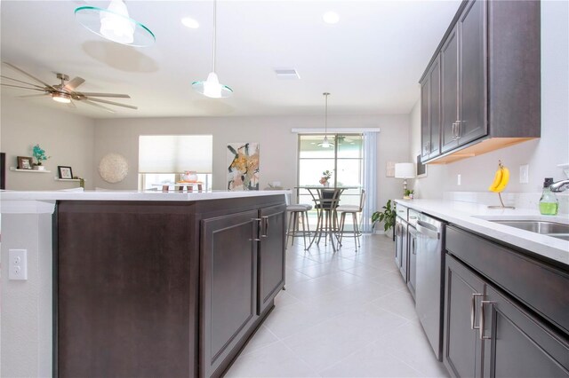 kitchen featuring sink, ceiling fan, dark brown cabinets, pendant lighting, and stainless steel dishwasher