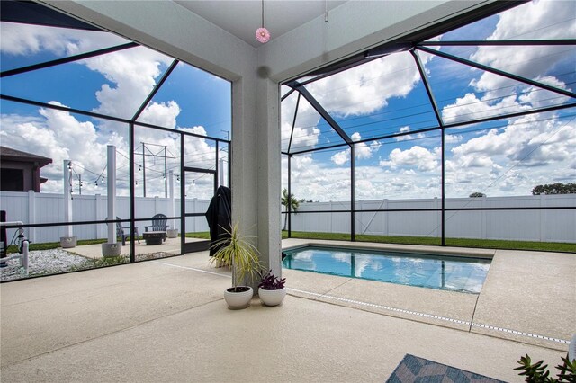 view of pool with a patio area and glass enclosure