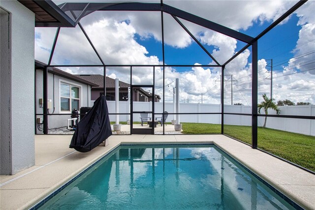 view of swimming pool featuring a lanai, a lawn, and a patio