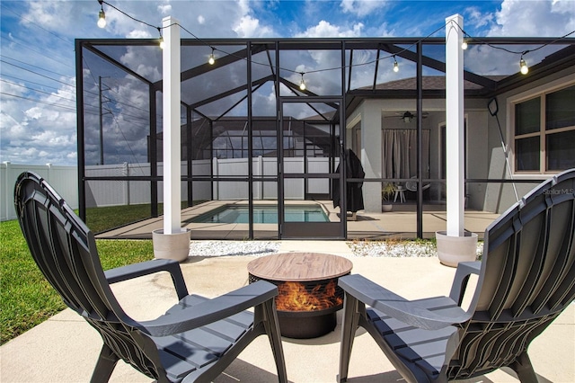 view of patio with a fenced in pool, a lanai, and a fire pit