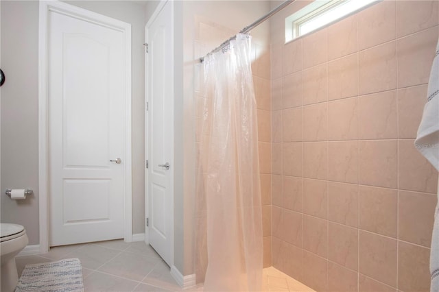 bathroom with toilet, a shower with shower curtain, and tile patterned floors