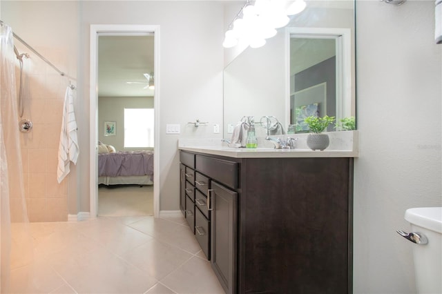 bathroom featuring tile patterned flooring, vanity, toilet, and curtained shower