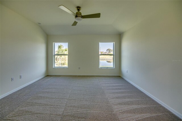 carpeted empty room with lofted ceiling, ceiling fan, and baseboards