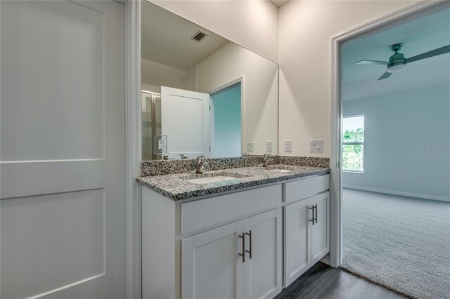 bathroom featuring ceiling fan, double vanity, a sink, and visible vents