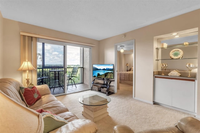 living room with light carpet, a textured ceiling, and ceiling fan