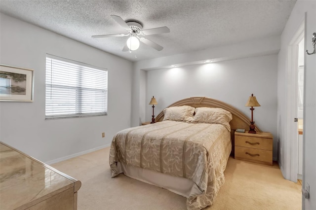 bedroom with ceiling fan, light carpet, and a textured ceiling