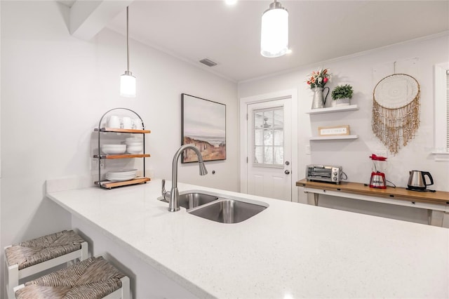 kitchen with ornamental molding, decorative light fixtures, and sink