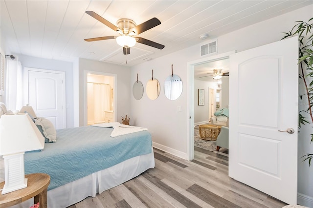 bedroom with ceiling fan, light hardwood / wood-style floors, and ensuite bath