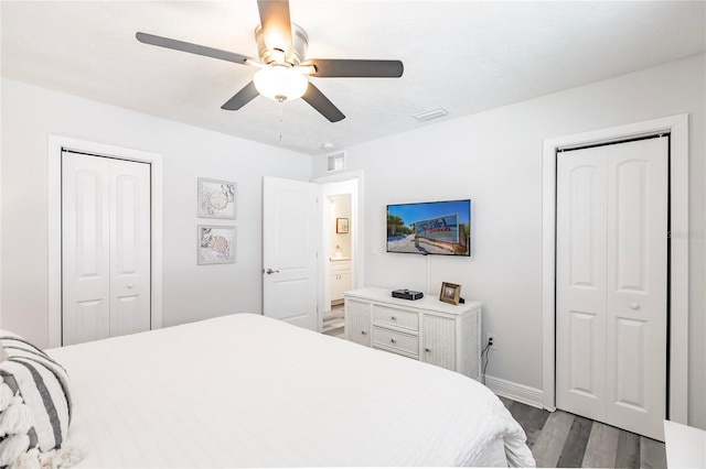 bedroom featuring ceiling fan, hardwood / wood-style floors, and two closets