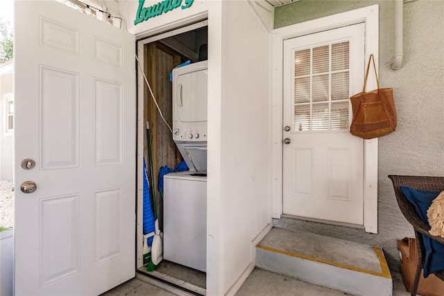 clothes washing area featuring stacked washer and dryer