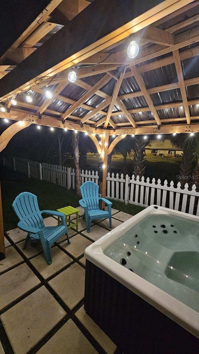 view of patio / terrace featuring a hot tub and a gazebo