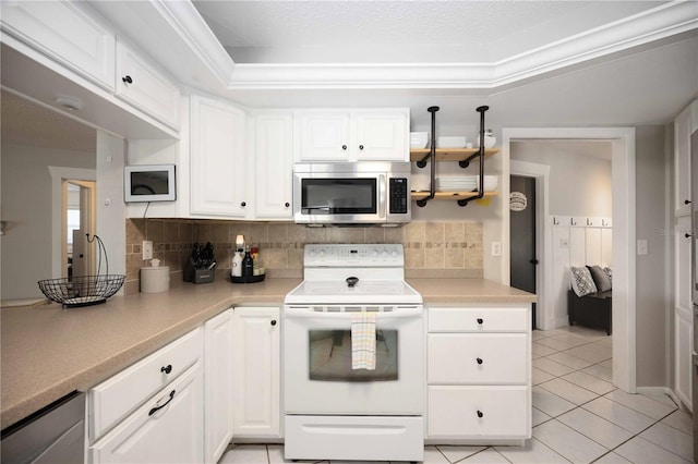 kitchen featuring light tile patterned floors, backsplash, a tray ceiling, white electric range, and white cabinetry