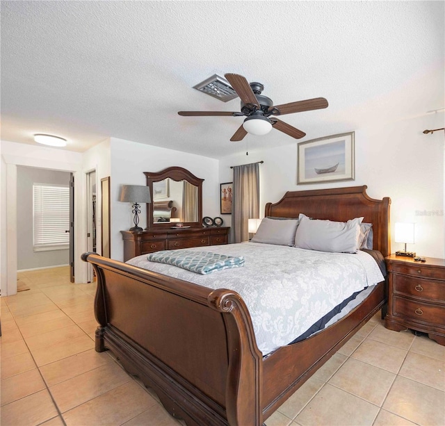 tiled bedroom with a textured ceiling and ceiling fan