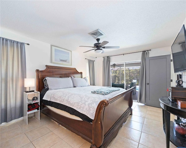 tiled bedroom with ceiling fan and a textured ceiling