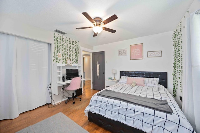 bedroom featuring a textured ceiling, light hardwood / wood-style flooring, and ceiling fan