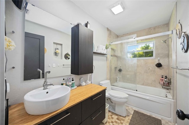 full bathroom featuring vanity, toilet, and bath / shower combo with glass door