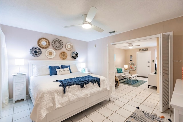 tiled bedroom featuring a textured ceiling and ceiling fan