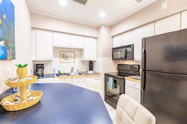 kitchen with sink, black appliances, white cabinets, and decorative backsplash